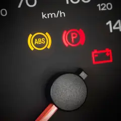 Warnleuchten im Auto: ABS, Handbremse und Batterie leuchten auf. Ein Blick auf den Tacho zeigt 50 km/h.