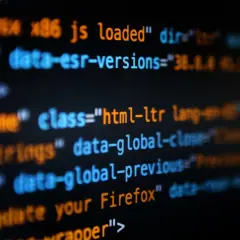 Bunte Codezeilen auf schwarzem Hintergrund. Hier siehst du, was ist coden: Befehle, die eine Webseite zum Leben erwecken, wie "html-ltr" oder "update your Firefox".