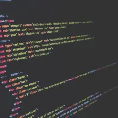 Nahaufnahme von Code auf einem dunklen Bildschirm, der HTML-Struktur und CSS-Links zeigt. Solche **Programmiersprache Beispiele** sind die Grundlage jeder Webseite.