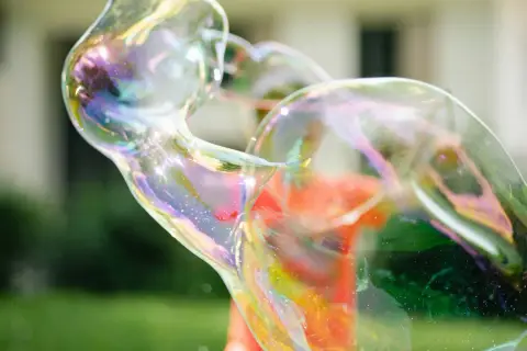 Bunte, schillernde Seifenblasen, die sich im Sonnenlicht wie magische Kugeln formen. Ein perfektes Beispiel, wie man Seifenblasen selber machen kann.