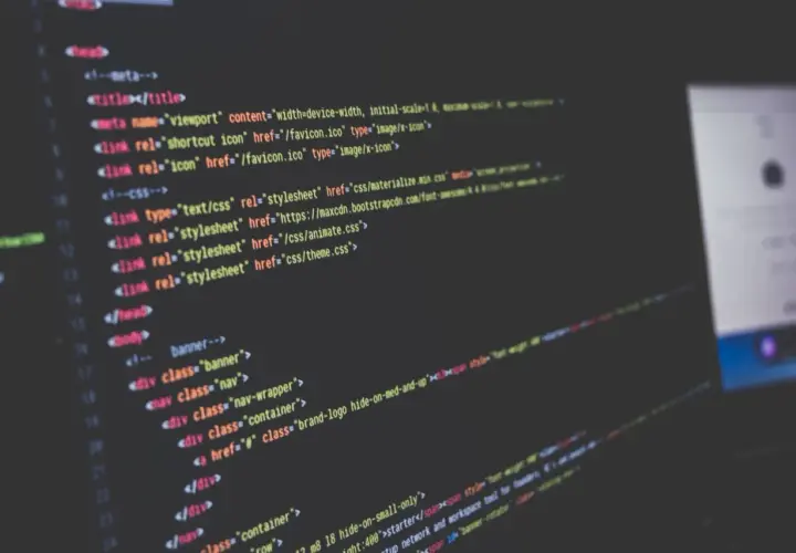 Nahaufnahme von Code auf einem dunklen Bildschirm, der HTML-Struktur und CSS-Links zeigt. Solche **Programmiersprache Beispiele** sind die Grundlage jeder Webseite.