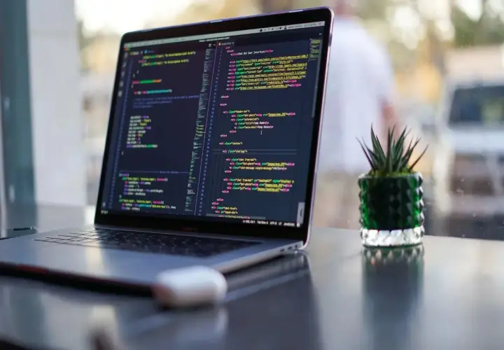 Ein Laptop zeigt Programmcode. Die Frage "wie lange braucht man um programmieren zu lernen" wird durch die vielen Zeilen Code visuell beantwortet.
