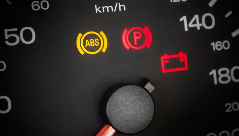 Warnleuchten im Auto: ABS, Handbremse und Batterie leuchten auf. Ein Blick auf den Tacho zeigt 50 km/h.