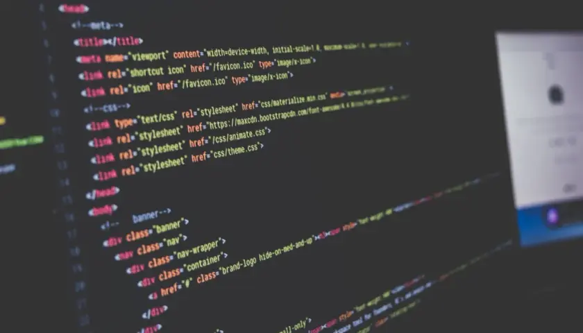 Nahaufnahme von Code auf einem dunklen Bildschirm, der HTML-Struktur und CSS-Links zeigt. Solche **Programmiersprache Beispiele** sind die Grundlage jeder Webseite.
