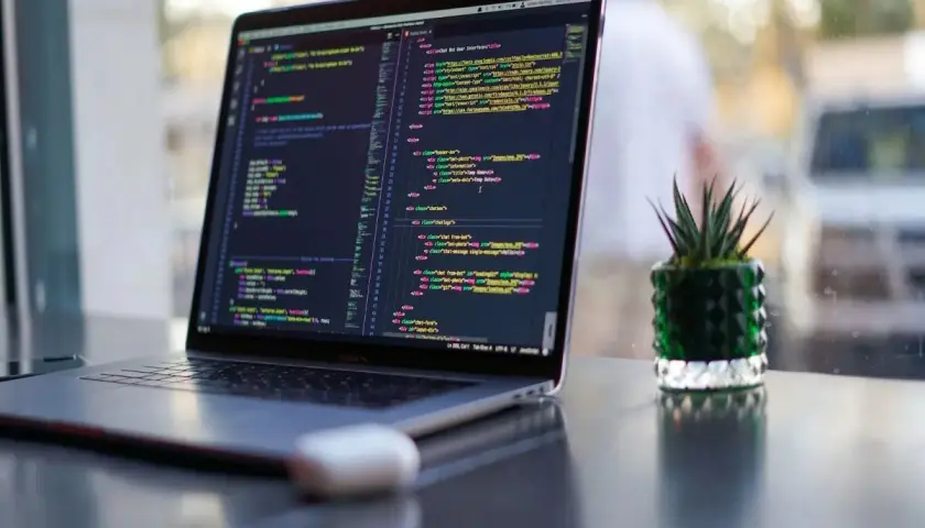Ein Laptop zeigt Programmcode. Die Frage "wie lange braucht man um programmieren zu lernen" wird durch die vielen Zeilen Code visuell beantwortet.
