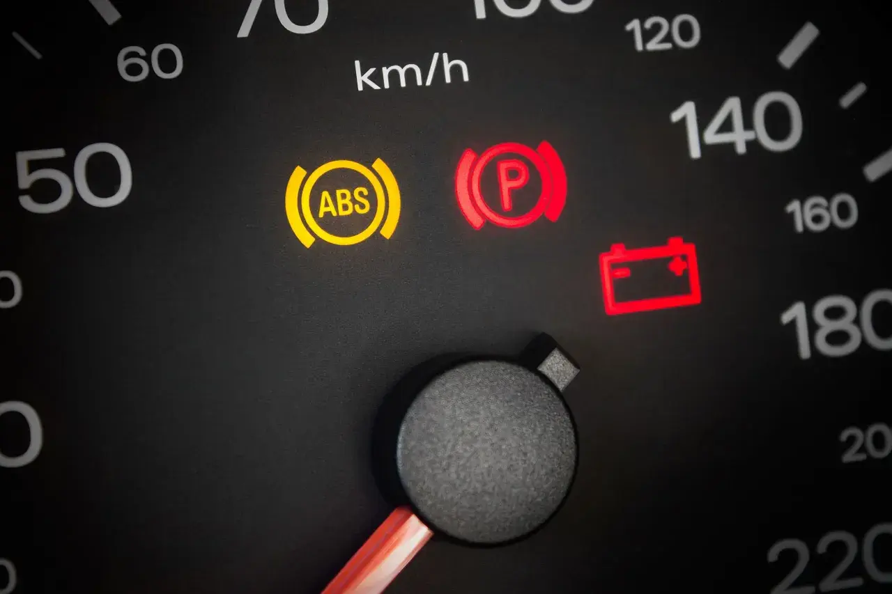 Warnleuchten im Auto: ABS, Handbremse und Batterie leuchten auf. Ein Blick auf den Tacho zeigt 50 km/h.