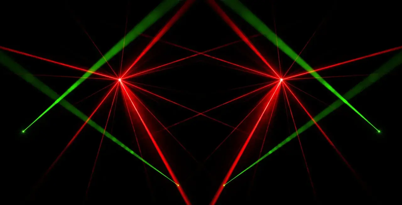 Rote und grüne Laserstrahlen kreuzen sich auf schwarzem Hintergrund. Das Bild zeigt, wie funktioniert ein laser, mit fokussierten Lichtpunkten und ausstrahlenden Strahlen.