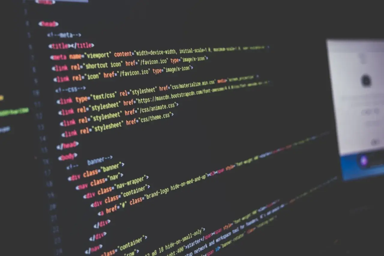Nahaufnahme von Code auf einem dunklen Bildschirm, der HTML-Struktur und CSS-Links zeigt. Solche **Programmiersprache Beispiele** sind die Grundlage jeder Webseite.