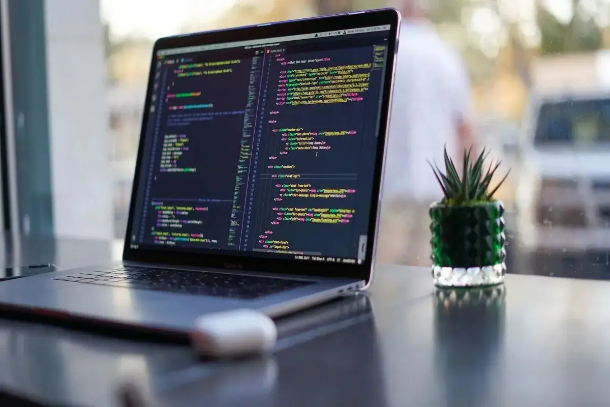 Ein Laptop zeigt Programmcode. Die Frage "wie lange braucht man um programmieren zu lernen" wird durch die vielen Zeilen Code visuell beantwortet.