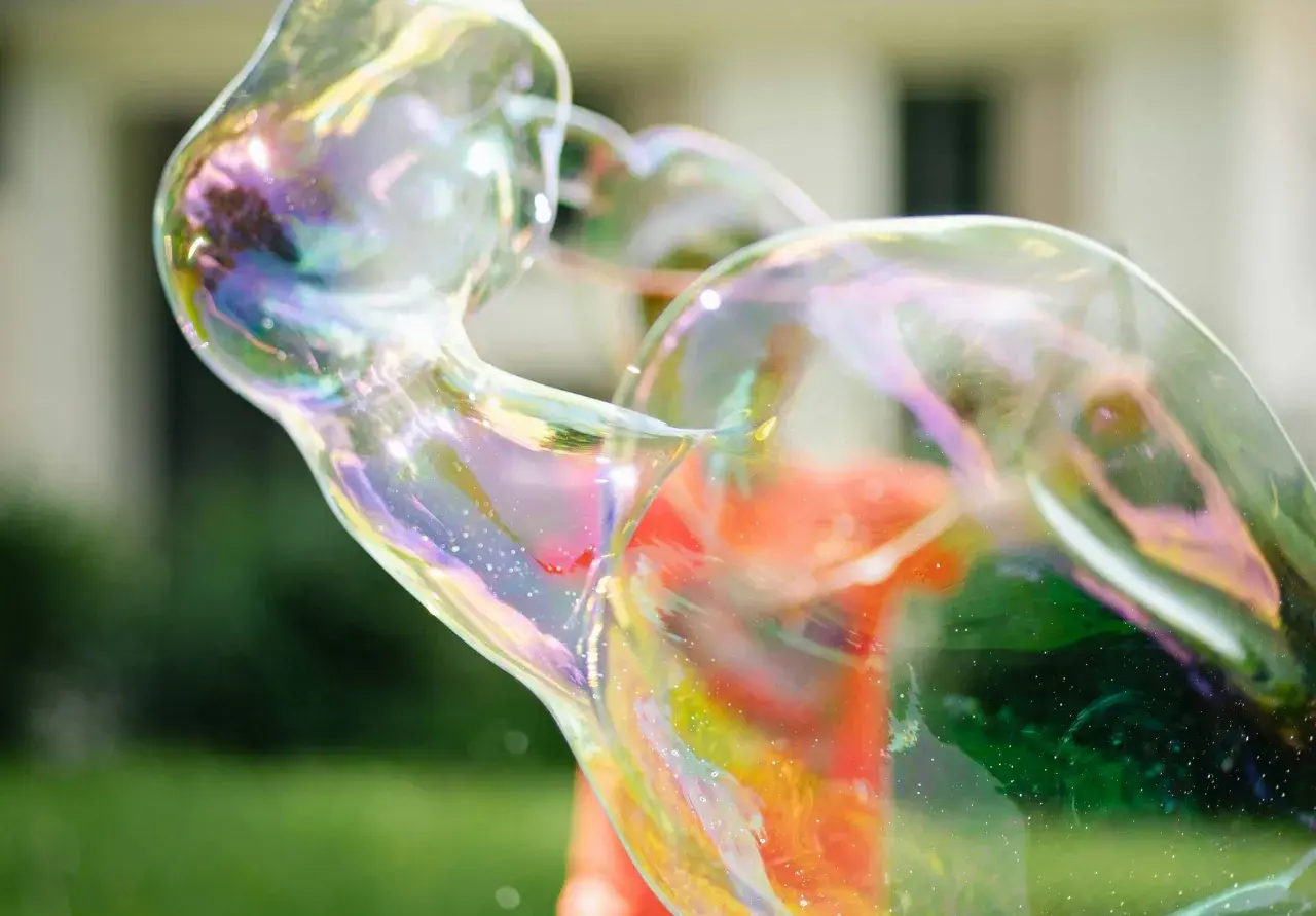 Bunte, schillernde Seifenblasen, die sich im Sonnenlicht wie magische Kugeln formen. Ein perfektes Beispiel, wie man Seifenblasen selber machen kann.