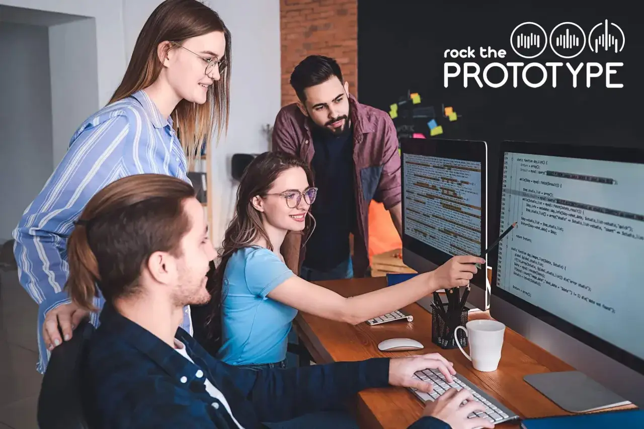 Programmierer arbeiten zusammen an Code auf zwei Bildschirmen. Sie diskutieren und lösen Probleme, um das Projekt