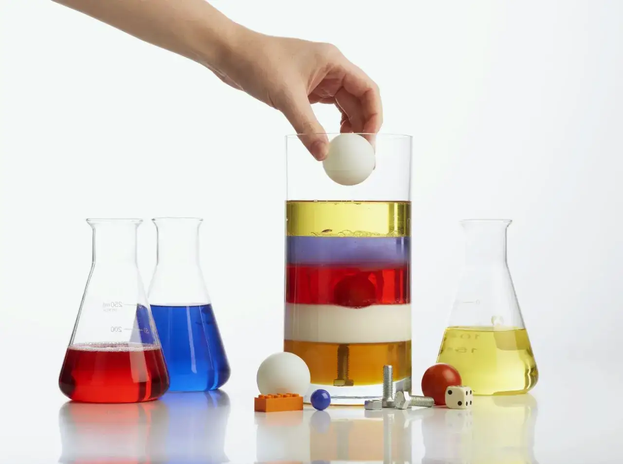 Experiment zur Dichte berechnen: Fl&uuml;ssigkeiten schichten sich nach Dichte. Ein Ei schwebt auf verschiedenen Ebenen.